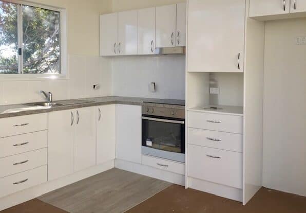 A clean white kitchen in a mobile granny flat.